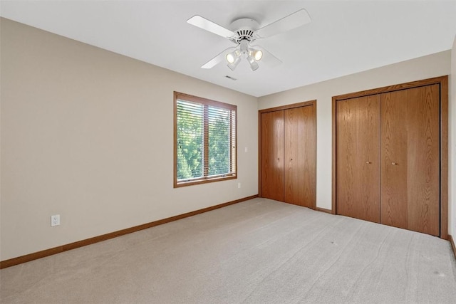 4644 Rapid Creek Trl NE, Iowa City, IA 52240 - unfurnished bedroom with multiple closets, light colored carpet, and a ceiling fan
