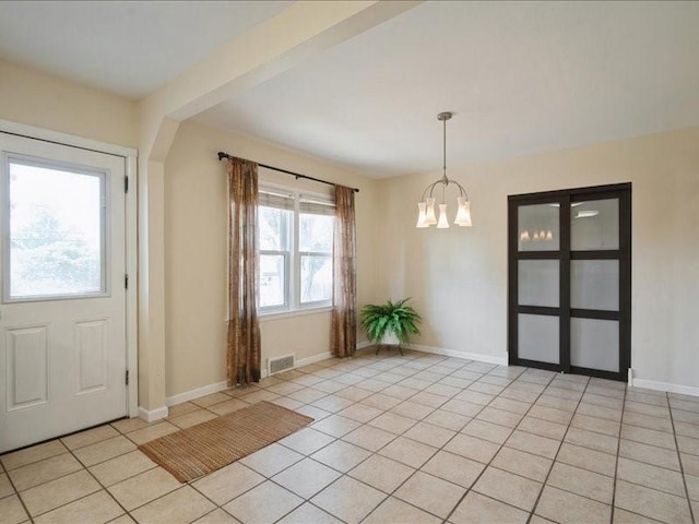 751 30th St NE, Cedar Rapids, IA 52402 - foyer featuring a chandelier, light tile patterned flooring, and baseboards
