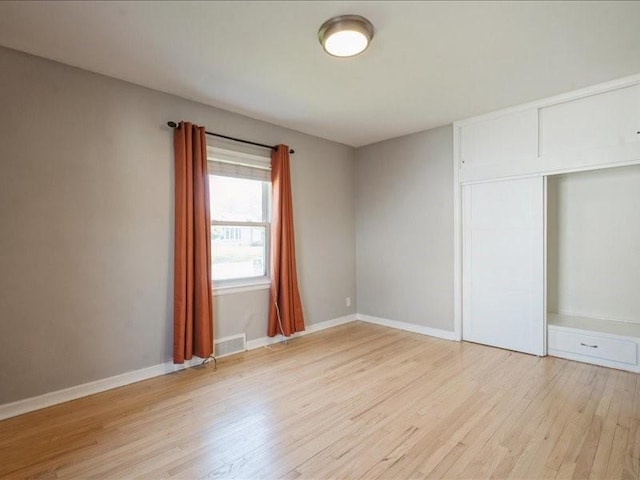 751 30th St NE, Cedar Rapids, IA 52402 - unfurnished bedroom featuring light wood-style flooring, a closet, and baseboards