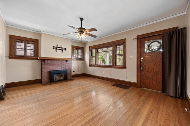 2607 B Ave NE, Cedar Rapids, IA 52402 - unfurnished living room with light wood-style flooring, ornamental molding, ceiling fan, baseboards, and a brick fireplace