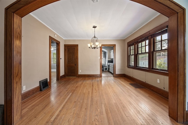 2607 B Ave NE, Cedar Rapids, IA 52402 - unfurnished dining area featuring arched walkways, crown molding, a chandelier, light wood-style flooring, and baseboards
