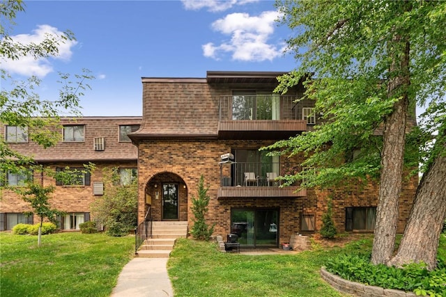 1015 Woodland Heights Ct SE Unit 14, Cedar Rapids, IA 52403 - view of front of property featuring a balcony, a front lawn, brick siding, and a shingled roof