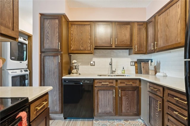 1015 Woodland Heights Ct SE Unit 14, Cedar Rapids, IA 52403 - kitchen with black dishwasher, a sink, stacked washer / drying machine, light countertops, and backsplash