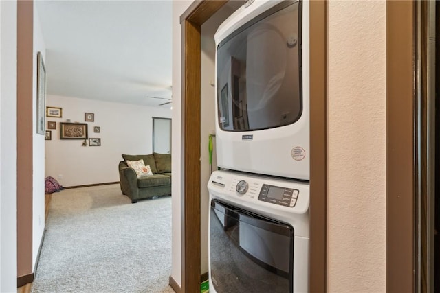 1015 Woodland Heights Ct SE Unit 14, Cedar Rapids, IA 52403 - washroom featuring stacked washer / drying machine, carpet, a ceiling fan, and baseboards