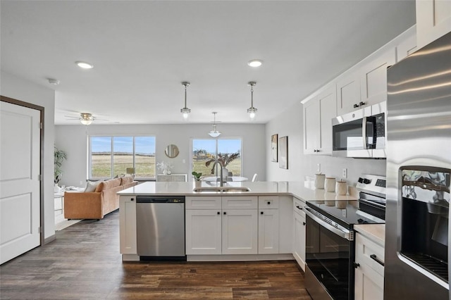 2004 Croell Ave, Tiffin, IA 52340 - kitchen featuring appliances with stainless steel finishes, a sink, a peninsula, recessed lighting, and white cabinetry
