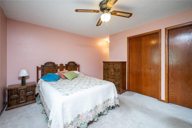 109 Oreole NE, Solon, IA 52333 - carpeted bedroom featuring multiple closets, ceiling fan, and a textured ceiling
