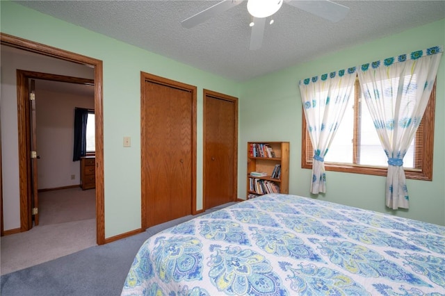 109 Oreole NE, Solon, IA 52333 - carpeted bedroom with two closets, a textured ceiling, and a ceiling fan