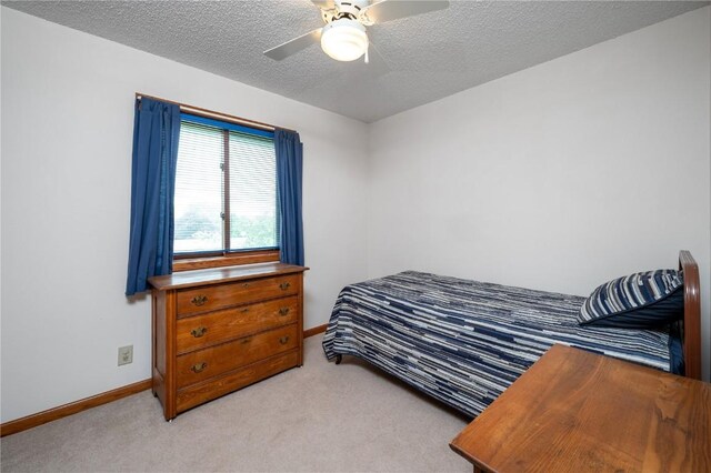 109 Oreole NE, Solon, IA 52333 - bedroom featuring baseboards, a textured ceiling, light carpet, and ceiling fan