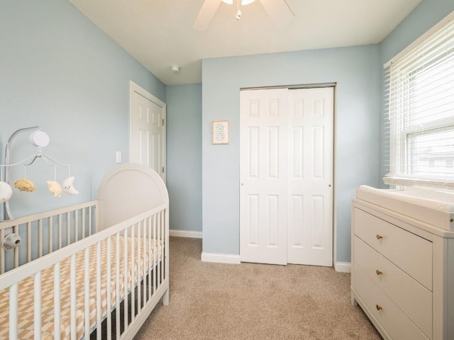 4721 Pine View Dr NE, Cedar Rapids, IA 52402 - bedroom featuring a closet, a crib, light carpet, baseboards, and ceiling fan