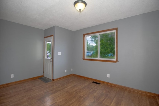 2339 Rompot St SE, Cedar Rapids, IA 52403 - spare room with plenty of natural light, wood finished floors, baseboards, and a textured ceiling
