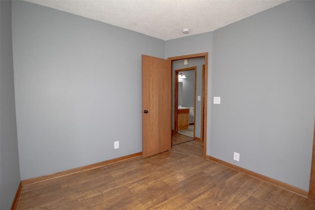 2339 Rompot St SE, Cedar Rapids, IA 52403 - spare room with wood finished floors, baseboards, a textured ceiling, and a smoke detector