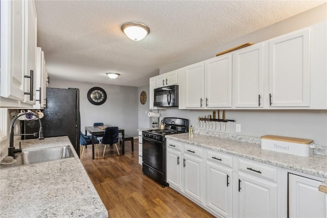281 NW Jacolyn Dr, Cedar Rapids, IA 52405 - kitchen with black appliances, a sink, white cabinetry, a textured ceiling, and light countertops