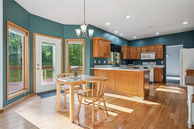 925 Rolling Creek Dr NE, Cedar Rapids, IA 52402 - kitchen featuring white appliances, light wood finished floors, light countertops, a chandelier, and healthy amount of natural light