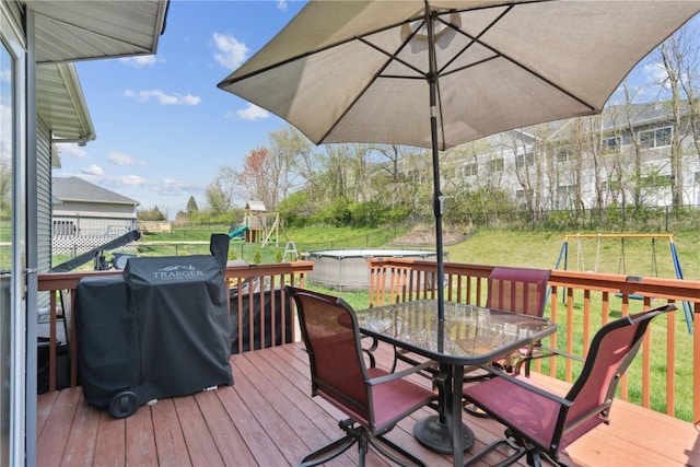 925 Rolling Creek Dr NE, Cedar Rapids, IA 52402 - deck featuring a playground, outdoor dining area, grilling area, and a lawn