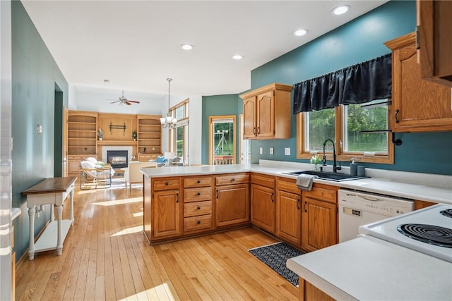 925 Rolling Creek Dr NE, Cedar Rapids, IA 52402 - kitchen with a glass covered fireplace, a peninsula, a ceiling fan, dishwasher, and light wood-style flooring