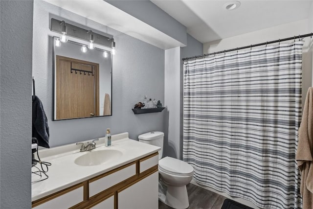 5525 Kacena Ave Unit 7, Marion, IA 52302 - bathroom featuring toilet, vanity, a textured wall, wood finished floors, and a shower with curtain