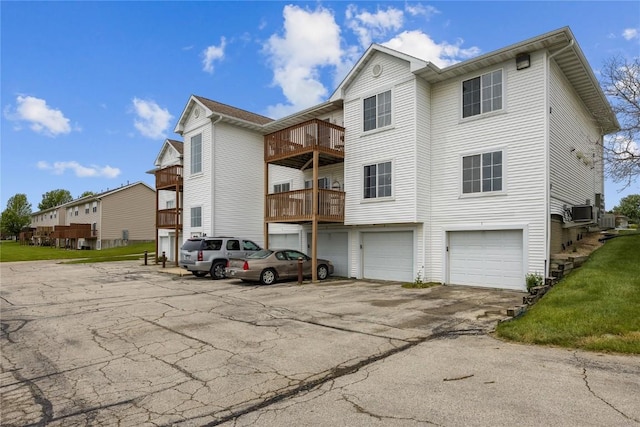 5525 Kacena Ave Unit 7, Marion, IA 52302 - rear view of house featuring a garage, a balcony, asphalt driveway, and cooling unit