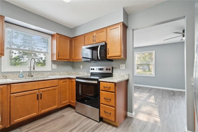 1626 High View Dr, Mount Vernon, IA 52314 - kitchen featuring appliances with stainless steel finishes, light wood-style flooring, a sink, and brown cabinetry