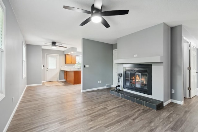 1626 High View Dr, Mount Vernon, IA 52314 - unfurnished living room with a ceiling fan, wood finished floors, baseboards, and a tile fireplace