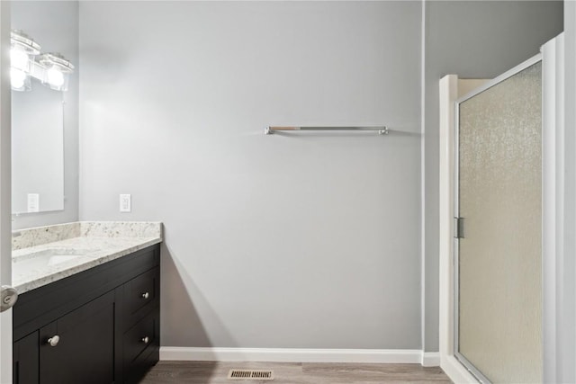 1626 High View Dr, Mount Vernon, IA 52314 - bathroom featuring vanity, wood finished floors, a stall shower, and baseboards