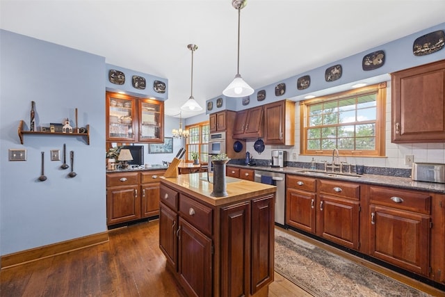 3009 Terry Dr SE, Cedar Rapids, IA 52403 - kitchen featuring appliances with stainless steel finishes, a sink, backsplash, dark wood-style floors, and a kitchen island