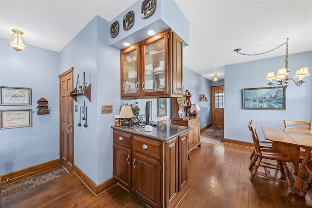 3009 Terry Dr SE, Cedar Rapids, IA 52403 - kitchen with baseboards, dark wood-type flooring, a chandelier, and glass insert cabinets