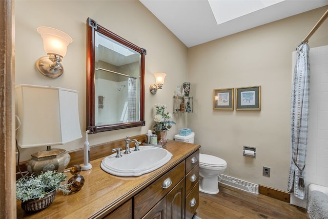 3009 Terry Dr SE, Cedar Rapids, IA 52403 - bathroom with a skylight, a baseboard heating unit, vanity, toilet, and wood finished floors