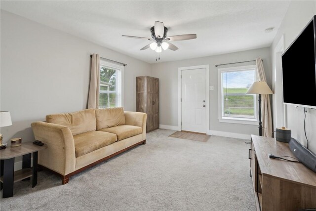 944 L St SW, Cedar Rapids, IA 52404 - living room featuring ceiling fan, light carpet, and baseboards
