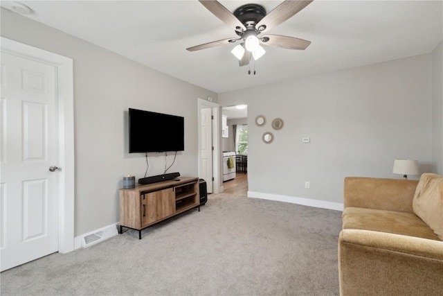 944 L St SW, Cedar Rapids, IA 52404 - living area with light carpet, a ceiling fan, and baseboards