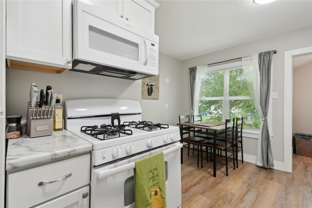 944 L St SW, Cedar Rapids, IA 52404 - kitchen with white appliances, light wood-style flooring, white cabinets, and light stone countertops