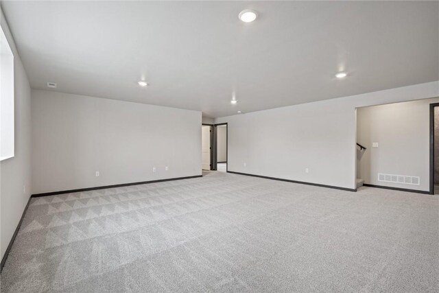 5017 Bluestem St SW, Kalona, IA 52247 - empty room with light colored carpet, baseboards, recessed lighting, and stairway