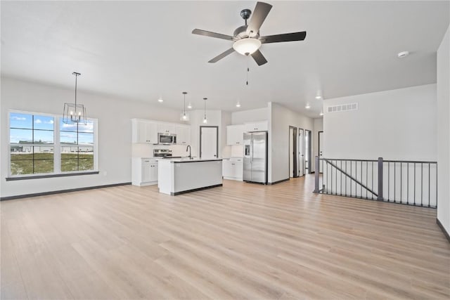 5017 Bluestem St SW, Kalona, IA 52247 - unfurnished living room featuring a ceiling fan, light wood-type flooring, recessed lighting, a sink, and baseboards