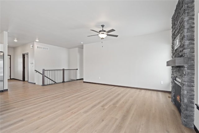 5017 Bluestem St SW, Kalona, IA 52247 - unfurnished living room featuring a fireplace, ceiling fan, light wood-type flooring, recessed lighting, and baseboards