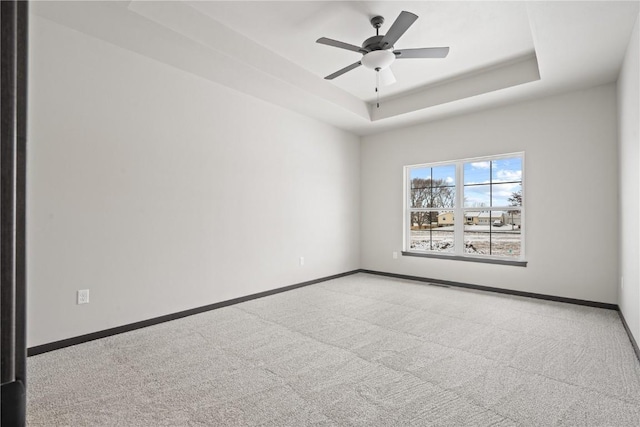 5017 Bluestem St SW, Kalona, IA 52247 - empty room with a tray ceiling, carpet, baseboards, and a ceiling fan