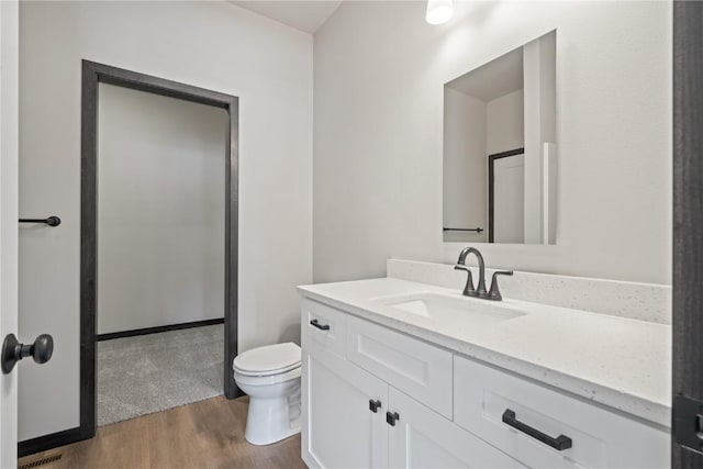 5017 Bluestem St SW, Kalona, IA 52247 - bathroom featuring wood finished floors, vanity, and toilet