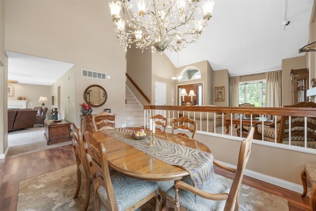 13 S View Dr NE, Iowa City, IA 52240 - dining space with a chandelier, wood finished floors, stairs, baseboards, and high vaulted ceiling