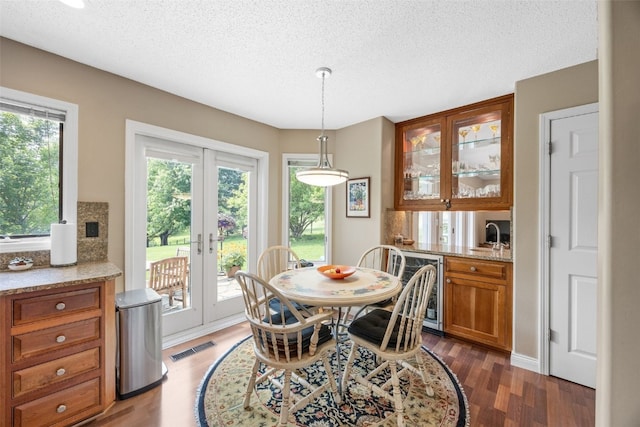 13 S View Dr NE, Iowa City, IA 52240 - dining room with wood finished floors, a textured ceiling, french doors, beverage cooler, and bar with sink