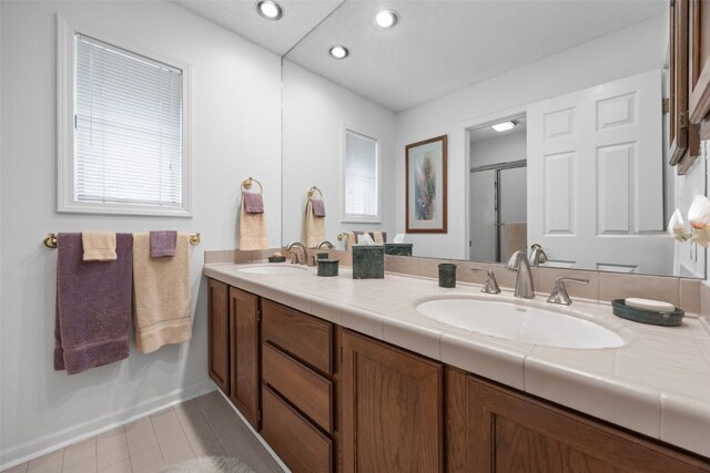 13 S View Dr NE, Iowa City, IA 52240 - bathroom featuring double vanity, a stall shower, recessed lighting, and tile patterned flooring