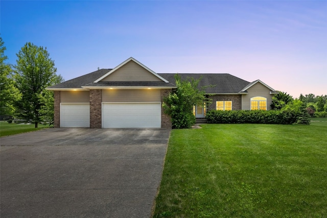 3017 Peaceful Dr, Riverside, IA 52327 - ranch-style house featuring driveway, a front lawn, an attached garage, and brick siding