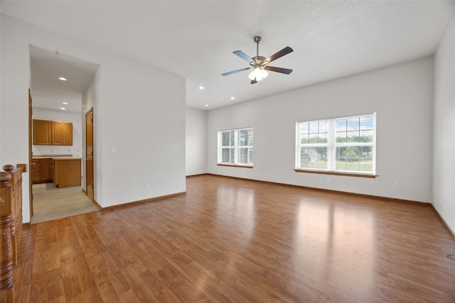 3017 Peaceful Dr, Riverside, IA 52327 - unfurnished room with light wood finished floors, ceiling fan, recessed lighting, and baseboards