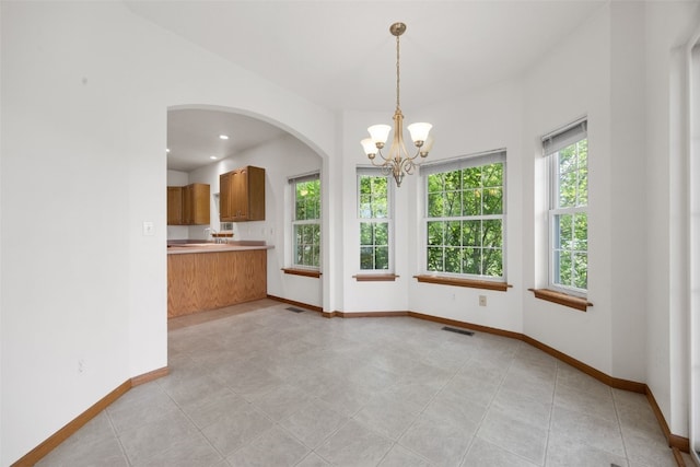 3017 Peaceful Dr, Riverside, IA 52327 - unfurnished dining area with arched walkways, baseboards, a chandelier, and a sink