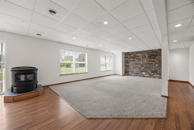 3017 Peaceful Dr, Riverside, IA 52327 - unfurnished living room with wood finished floors, baseboards, a paneled ceiling, a wood stove, and recessed lighting