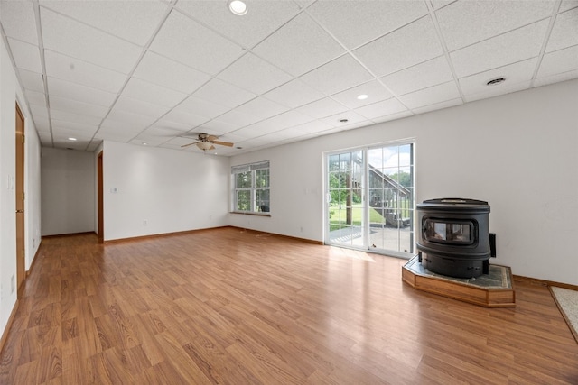 3017 Peaceful Dr, Riverside, IA 52327 - unfurnished living room with a wood stove, wood finished floors, a drop ceiling, baseboards, and ceiling fan