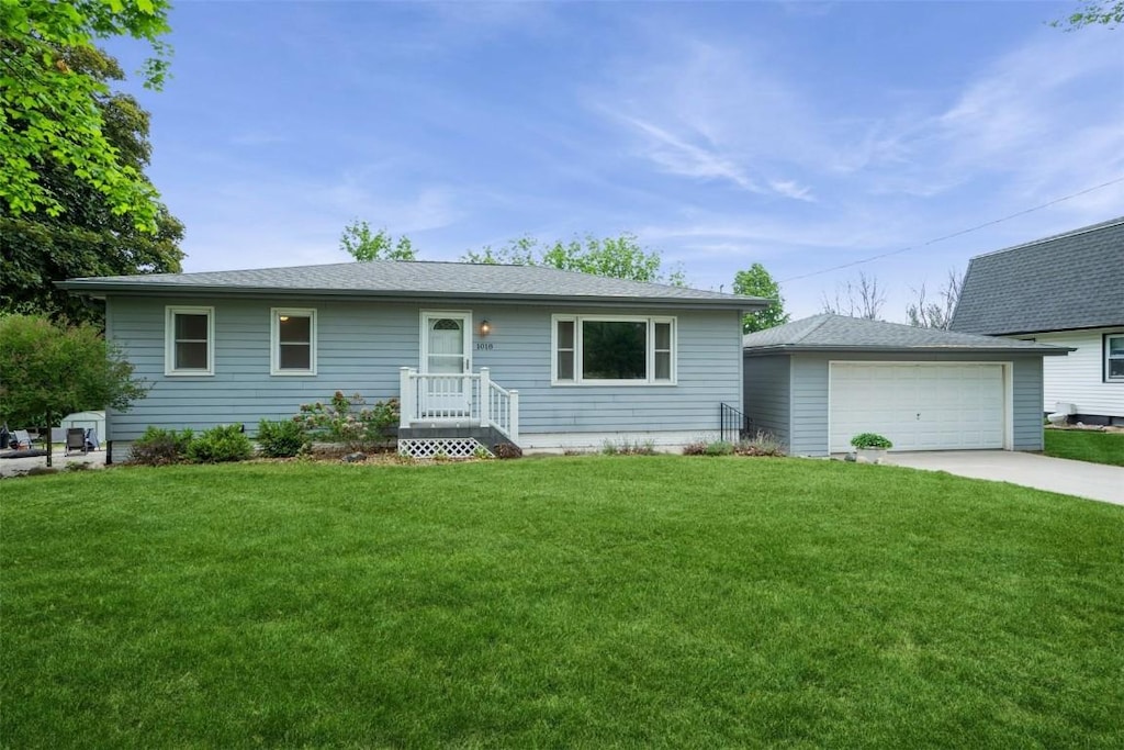 1018 E 1st St, Center Point, IA 52213 - ranch-style house featuring an outbuilding, a front yard, and a detached garage