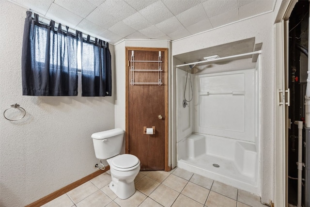 17 C Ave, Newhall, IA 52315 - full bathroom with tile patterned floors, a stall shower, toilet, a textured wall, and baseboards