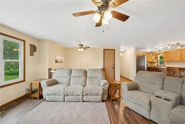 1805 4th Ave, South Amana, IA 52334 - living area with wood finished floors, a ceiling fan, and baseboards