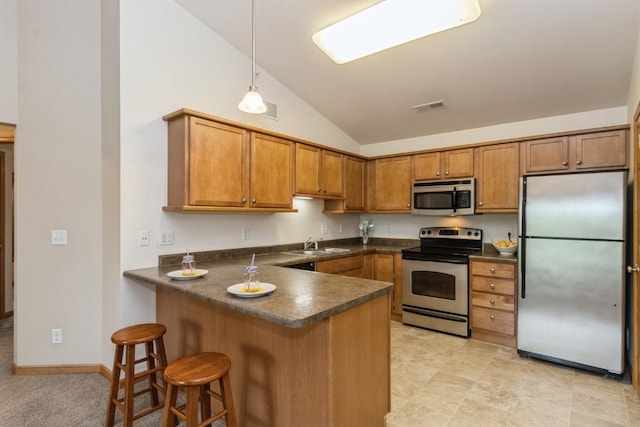 1080 Rachael St Unit 304, North Liberty, IA 52317 - kitchen featuring stainless steel appliances, dark countertops, brown cabinets, lofted ceiling, and a peninsula