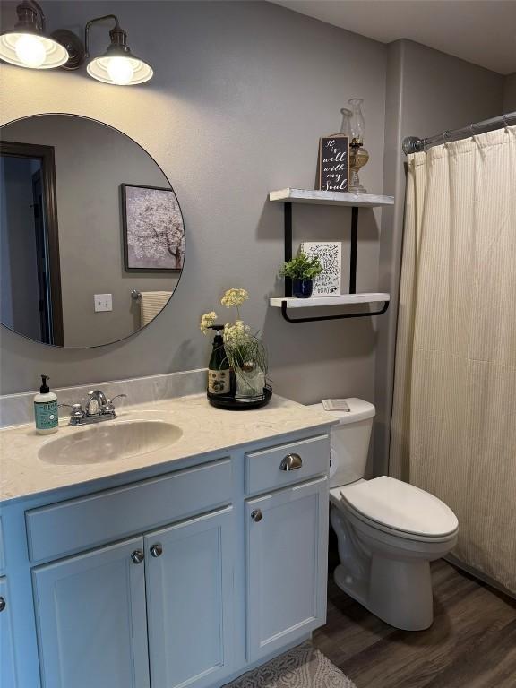 622 Prairie Hill Dr, Atkins, IA 52206 - bathroom with vanity, toilet, wood finished floors, and curtained shower