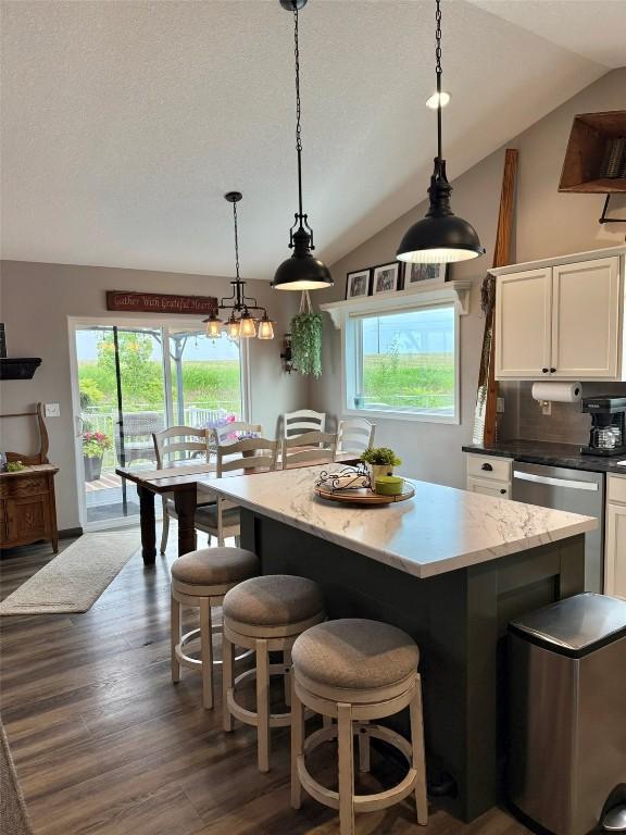 622 Prairie Hill Dr, Atkins, IA 52206 - kitchen with vaulted ceiling, white cabinets, a kitchen island, dark wood-style flooring, and a breakfast bar area