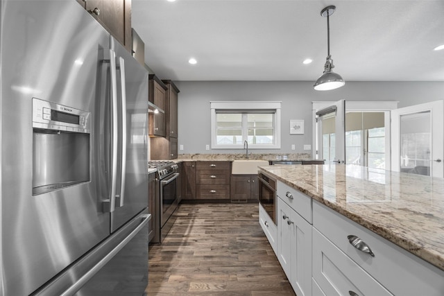 6318 Rapids Ridge Rd NE, Cedar Rapids, IA 52411 - kitchen featuring appliances with stainless steel finishes, a sink, dark wood-type flooring, recessed lighting, and light stone countertops